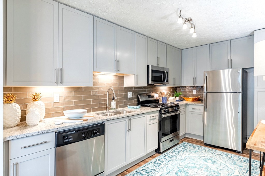 a kitchen with stainless steel appliances and white cabinets