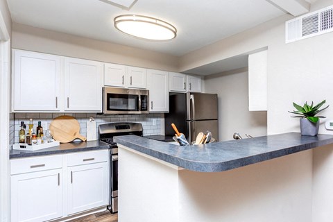 a kitchen with white cabinets and stainless steel appliances