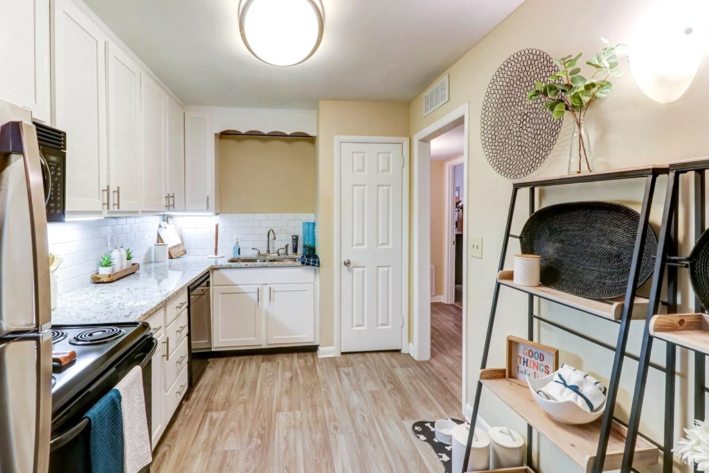 a renovated kitchen with white cabinets and a white door