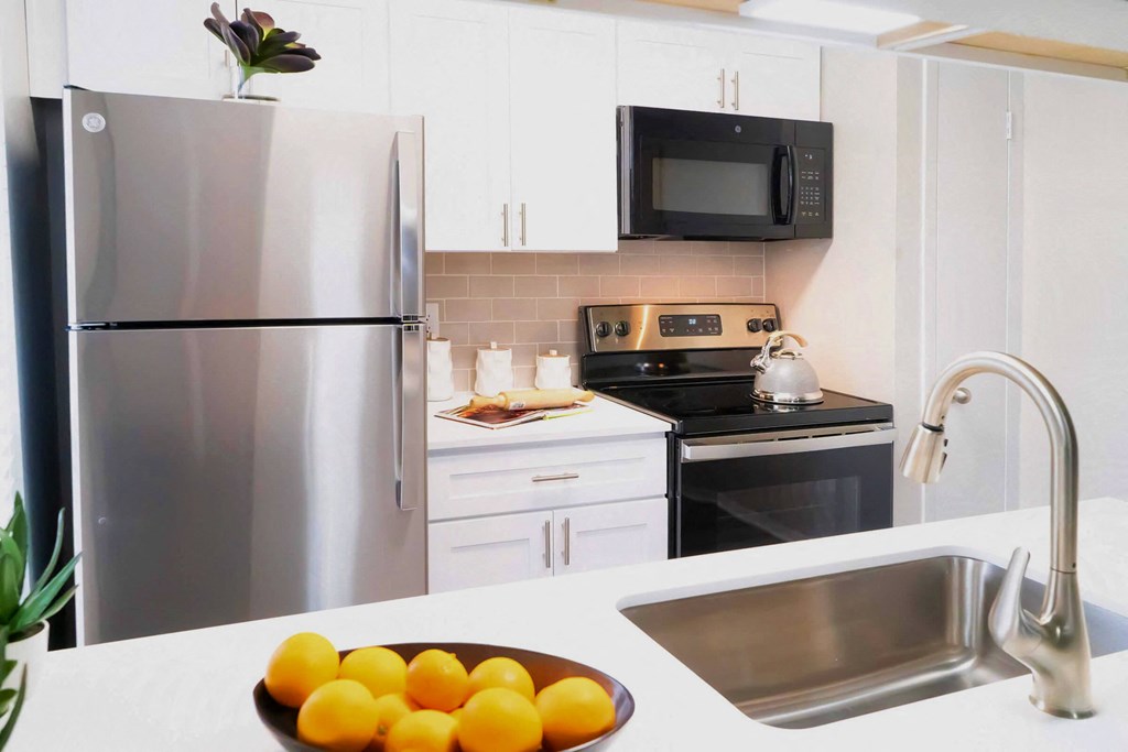 a kitchen with stainless steel appliances and a sink with oranges at Keller Oaks, Carrollton, TX ?