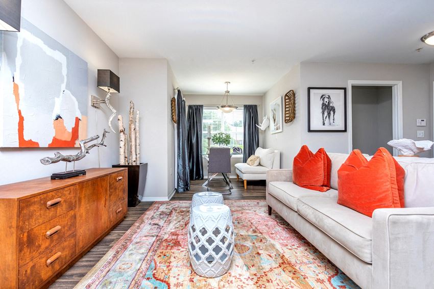 a living room with white furniture and orange pillows
