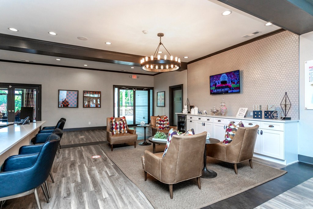 a large lobby with chairs and a bar and a tv