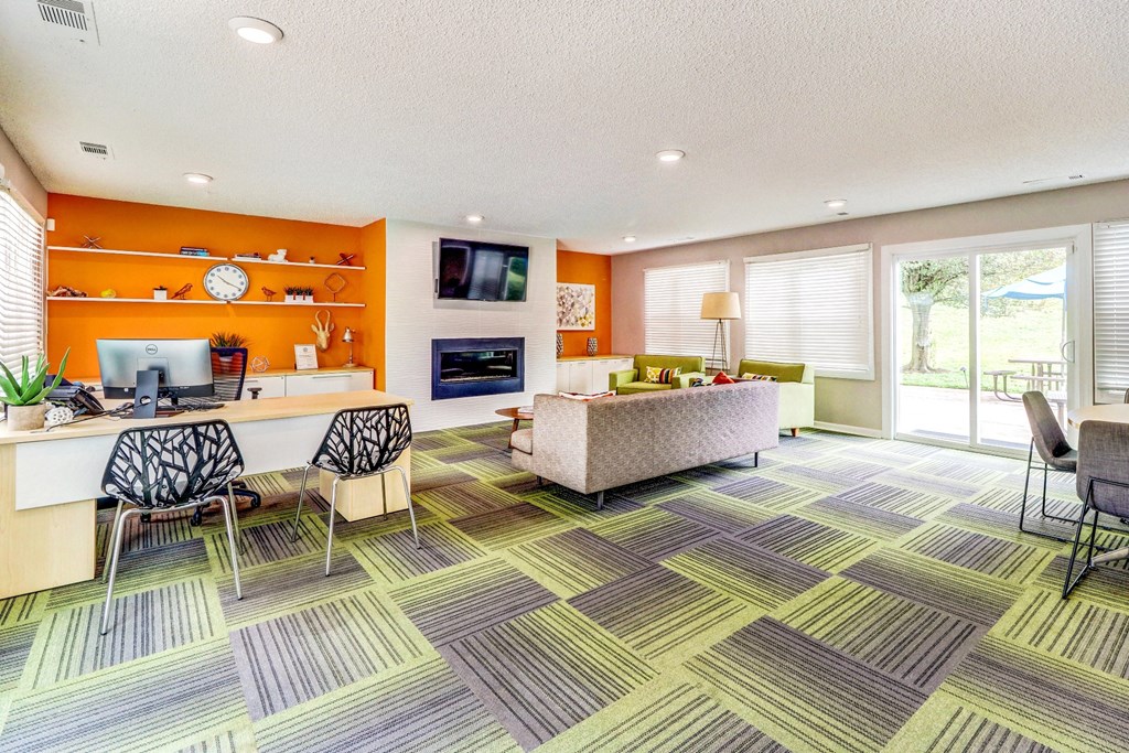 A room with a desk, chairs, and a couch.