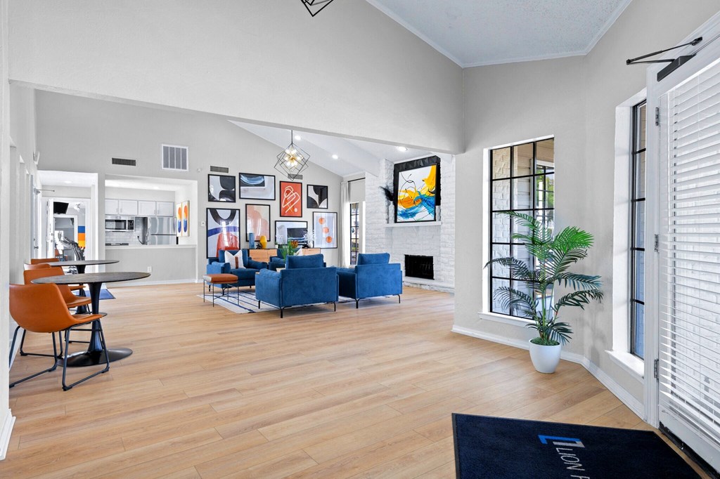the living room and dining area of a house with white walls and wood floors