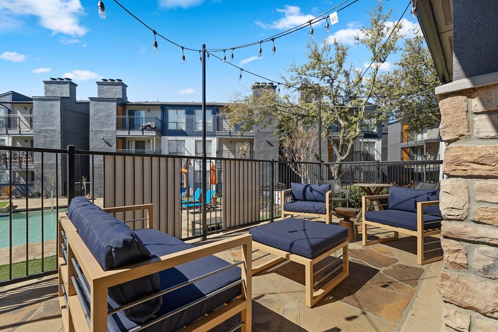 a furnished patio with a pool and lounge chairs at District 2308, Arlington 