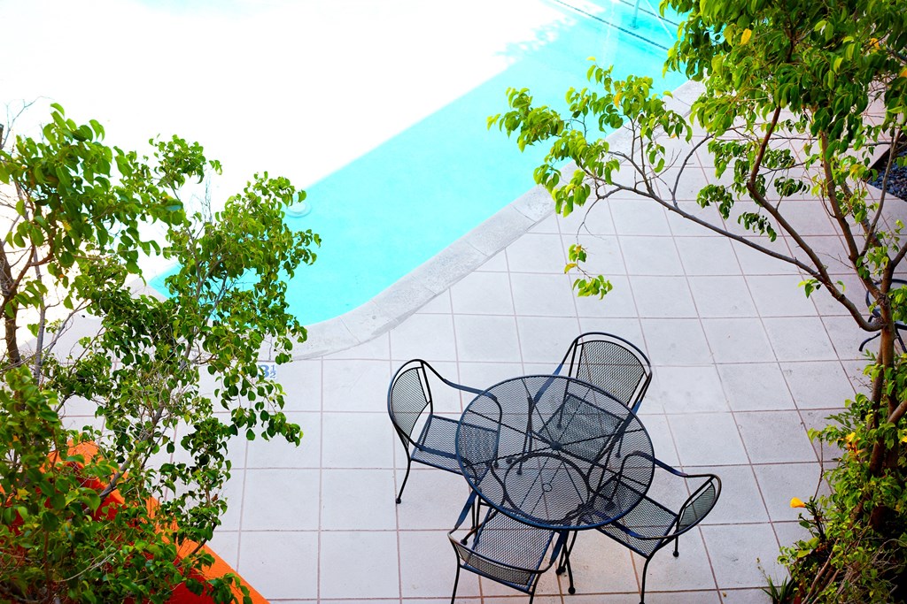 table with four chairs by swimming pool