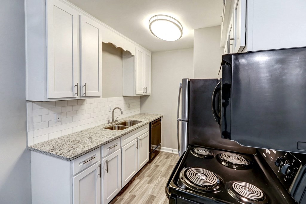 a kitchen with white cabinets and a black stove and refrigerator