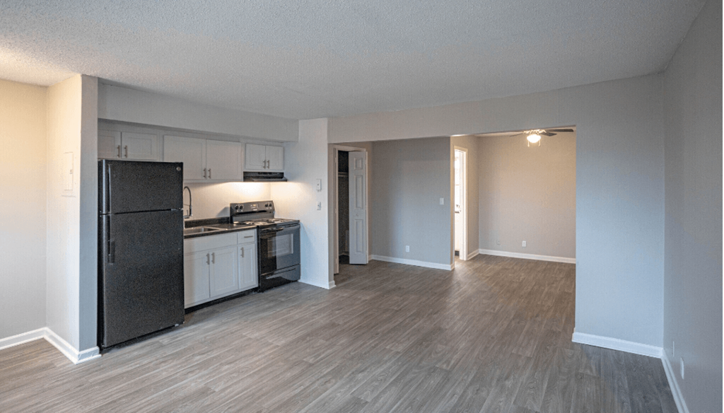 living room with a renovated kitchen with a stove and refrigerator