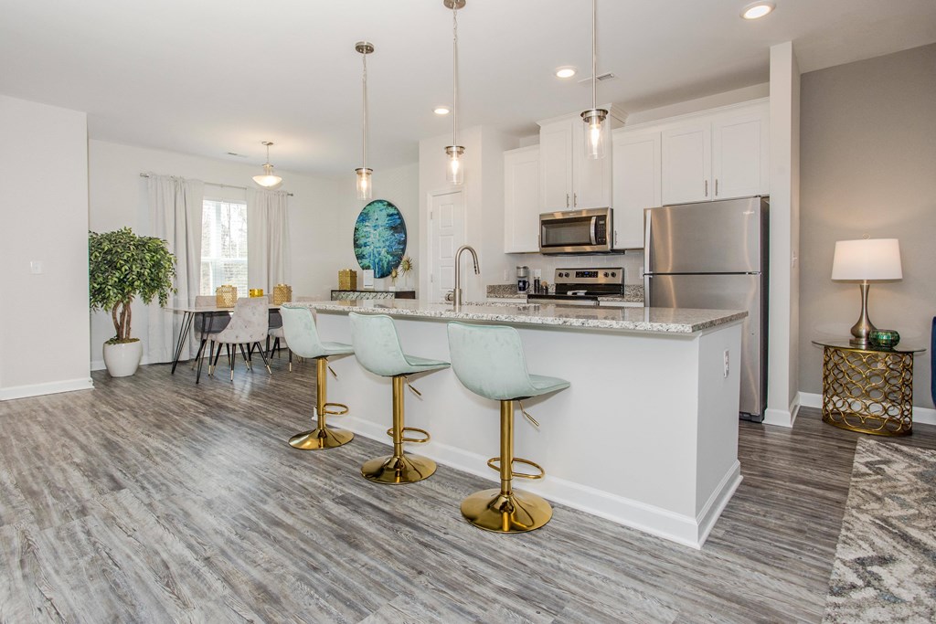 an open kitchen with white cabinets and a marble counter top