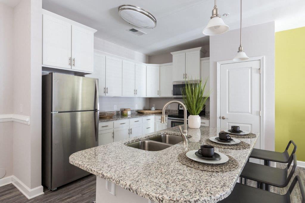 a kitchen with a granite counter top and a stainless steel refrigerator