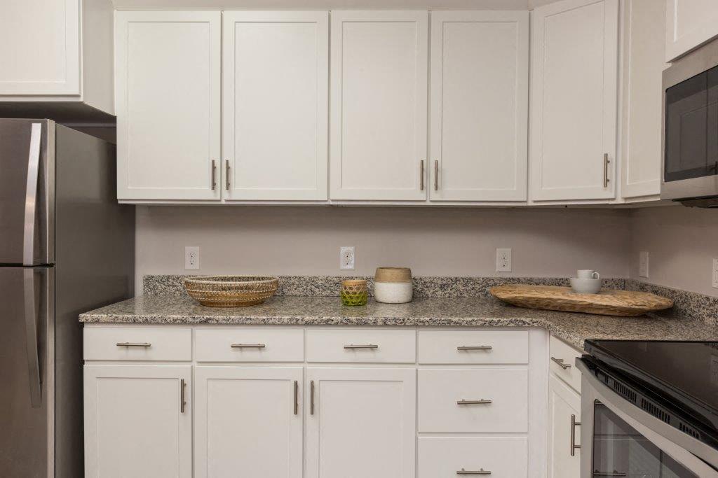 a kitchen with white cabinets and granite counter tops