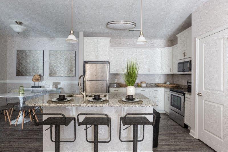 a kitchen with a counter and chairs in it