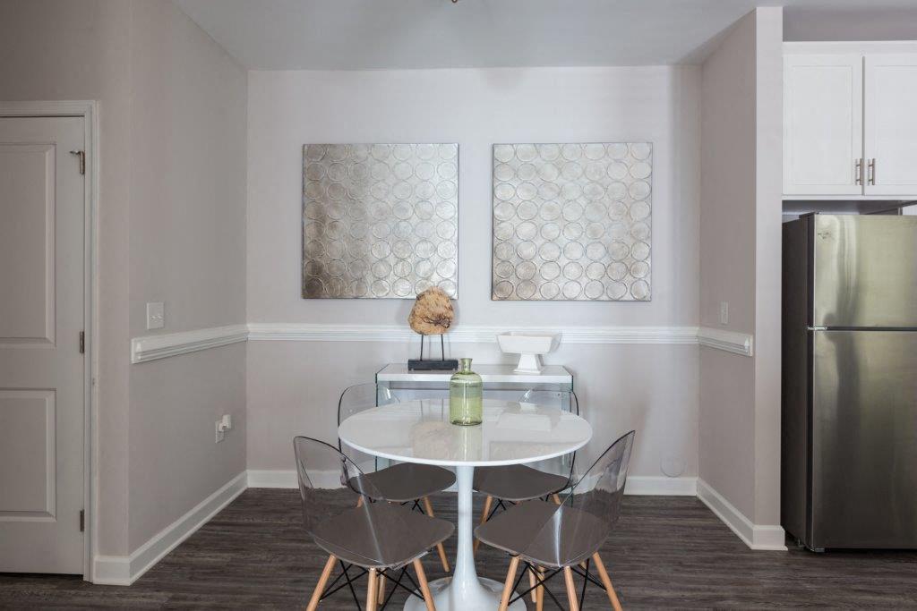 a dining room with a table and chairs and a refrigerator