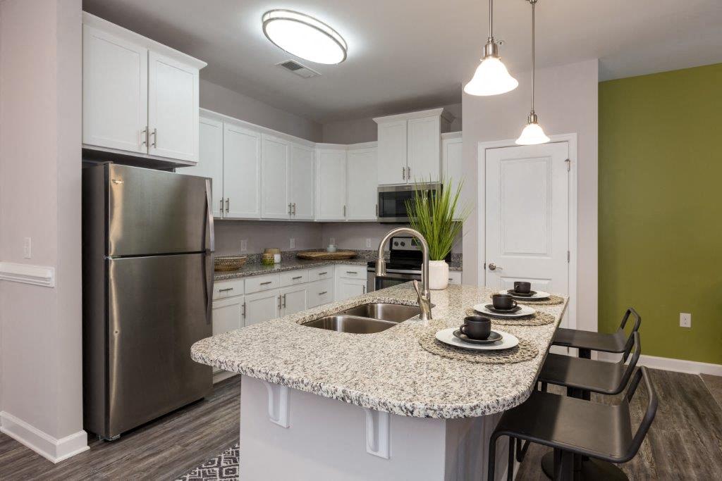 a kitchen with a counter top and a stainless steel refrigerator
