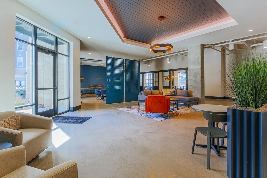 a lobby with couches chairs and tables and a large window