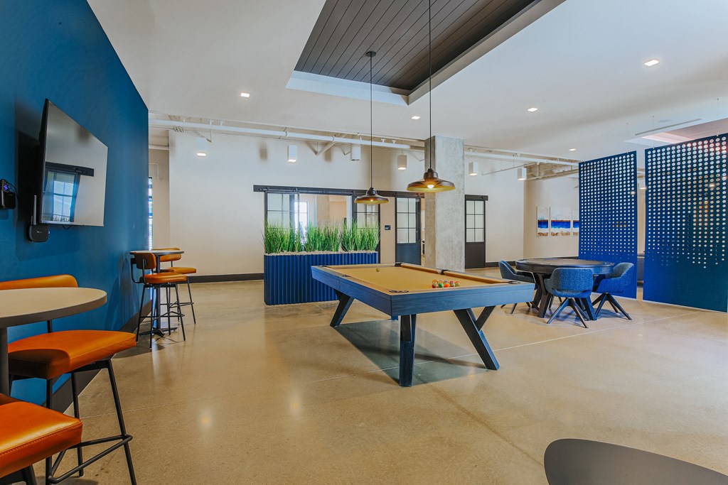 a game room with a blue pool table and tables and chairs
