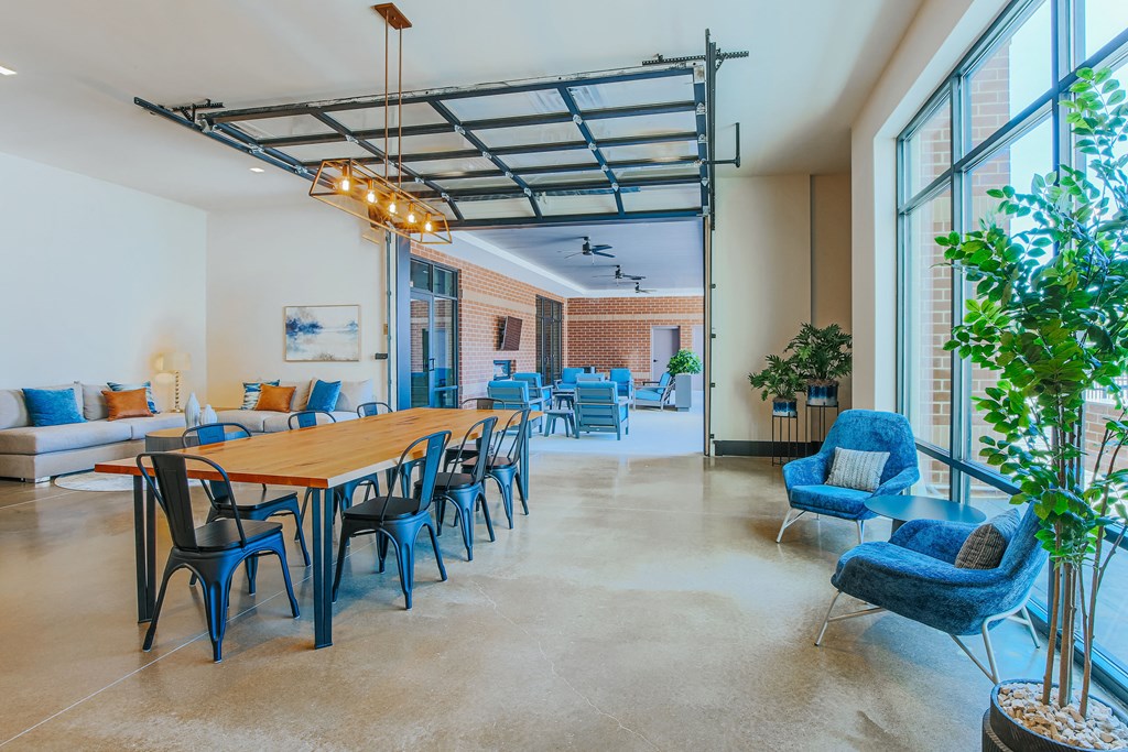 a dining room with a table and chairs and a living room with large windows