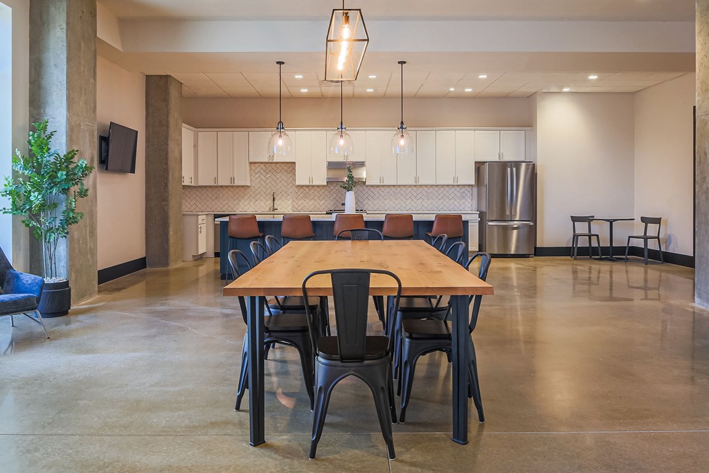 a large dining room with a table and chairs and a kitchen