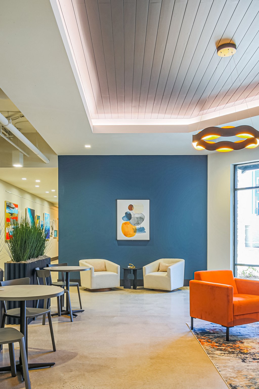 a lobby with a blue wall and chairs and tables