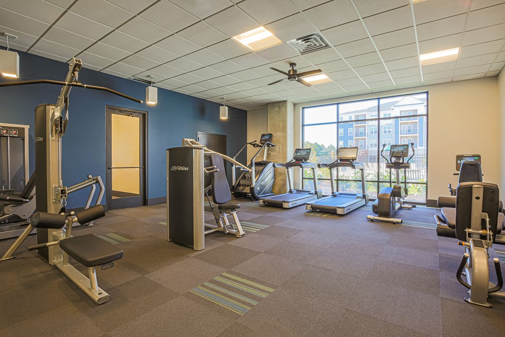 a gym with weights and other exercise equipment and a window