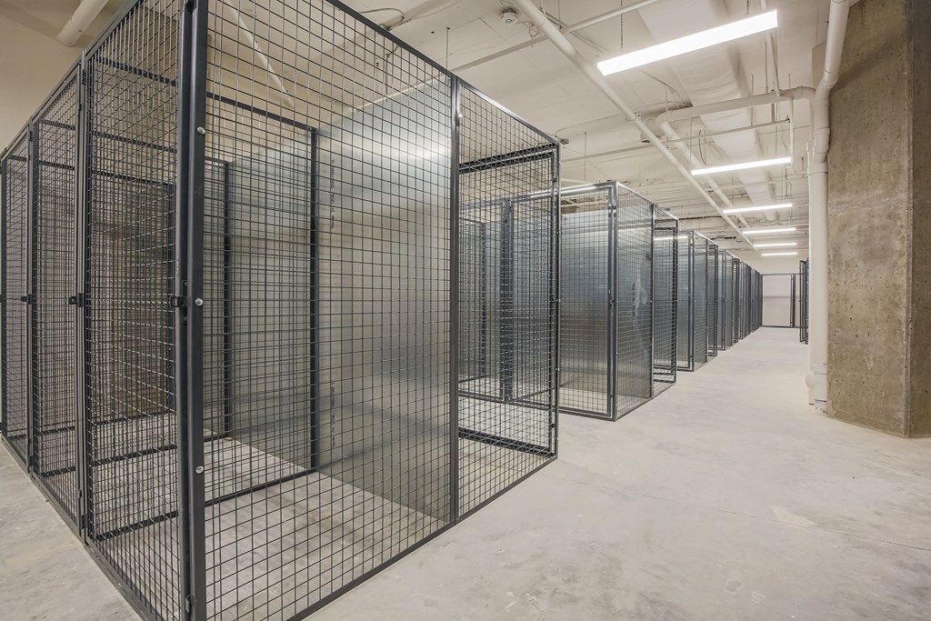 a long line of cages in a building with concrete floors