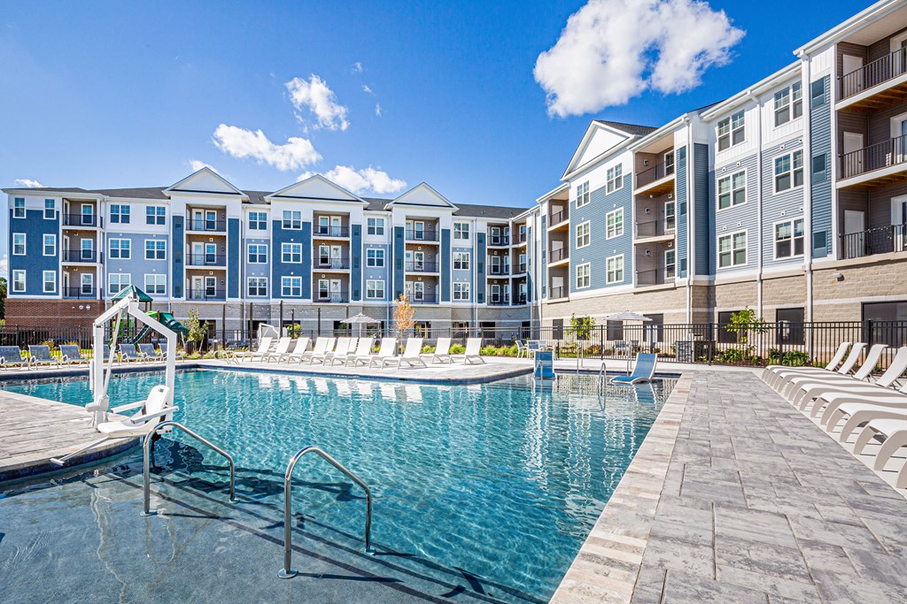 a swimming pool with an apartment building in the background
