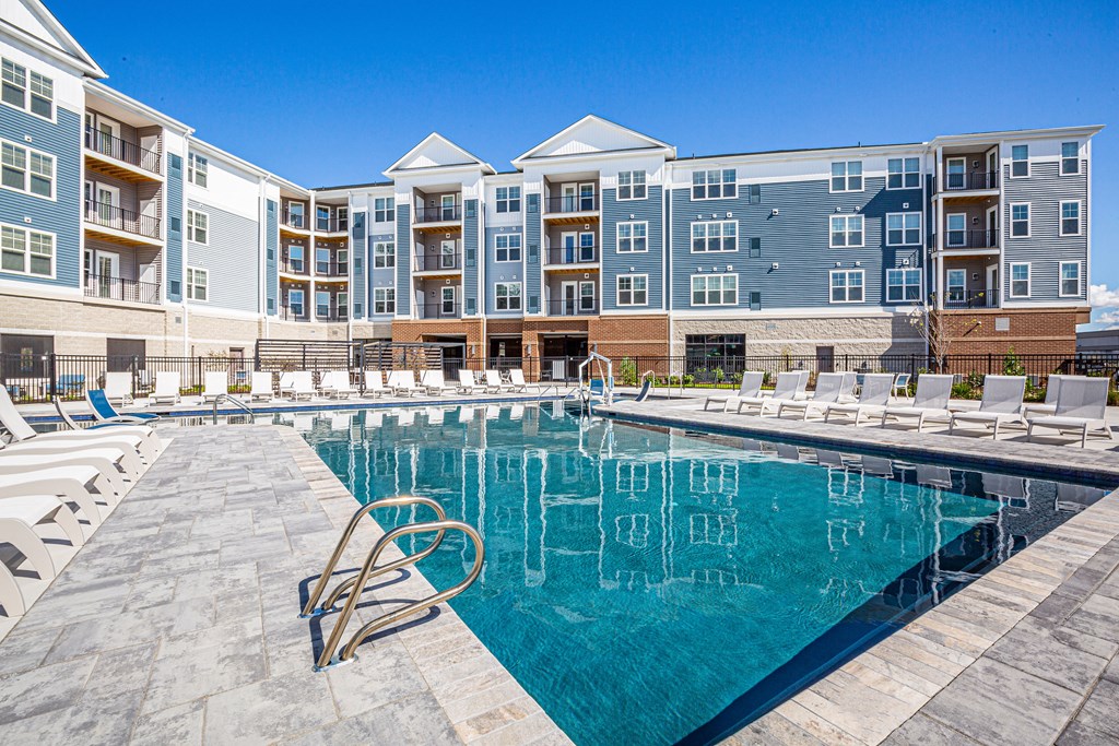 a swimming pool with an apartment building in the background