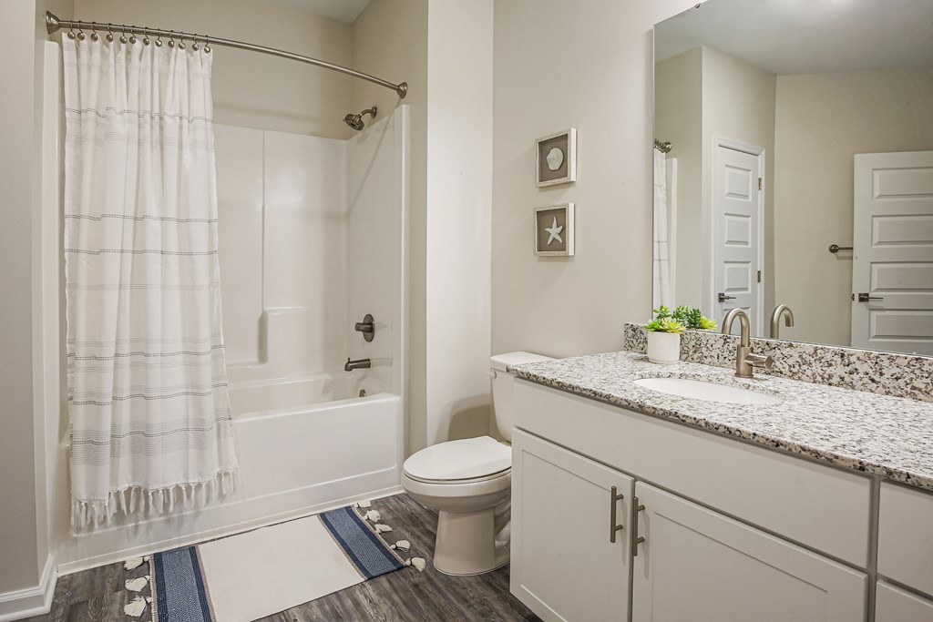 a bathroom with a shower and a toilet and a sink