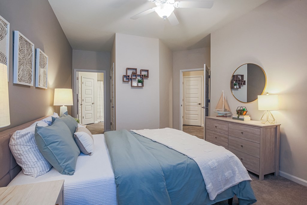 a bedroom with a bed and a dresser and a mirror