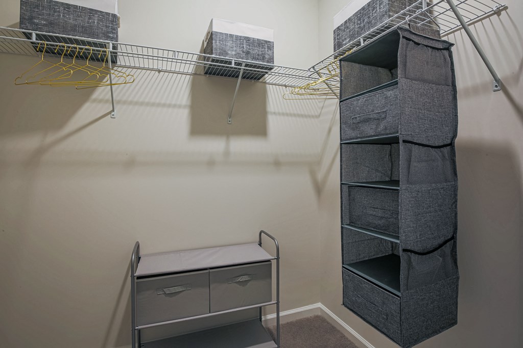 a walk in closet with shelves and a filing cabinet