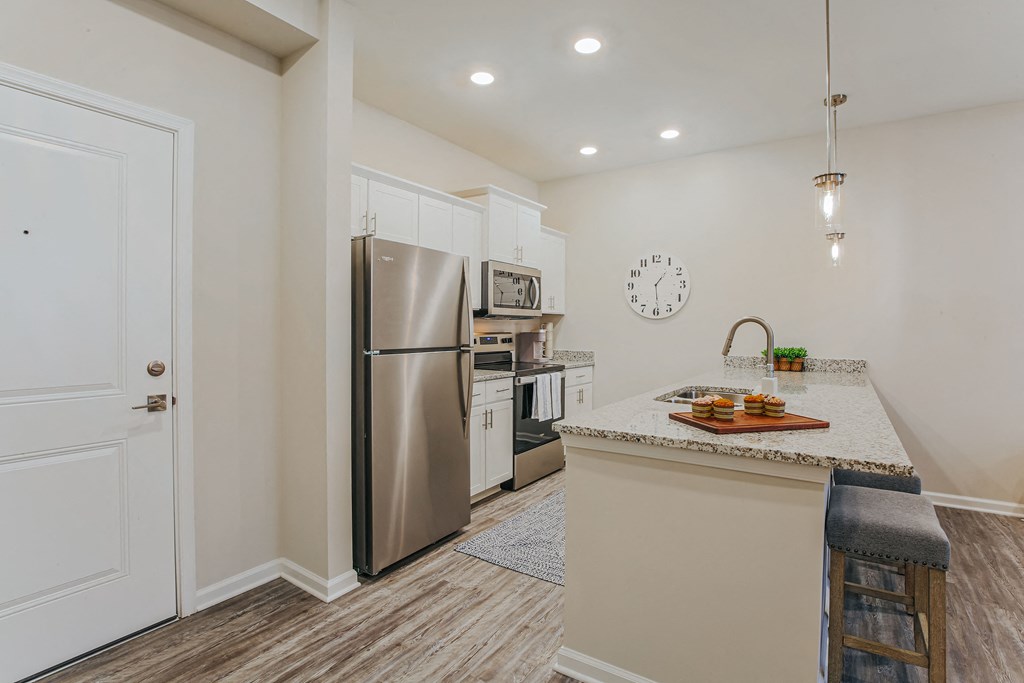 a kitchen with a island and stainless steel refrigerator
