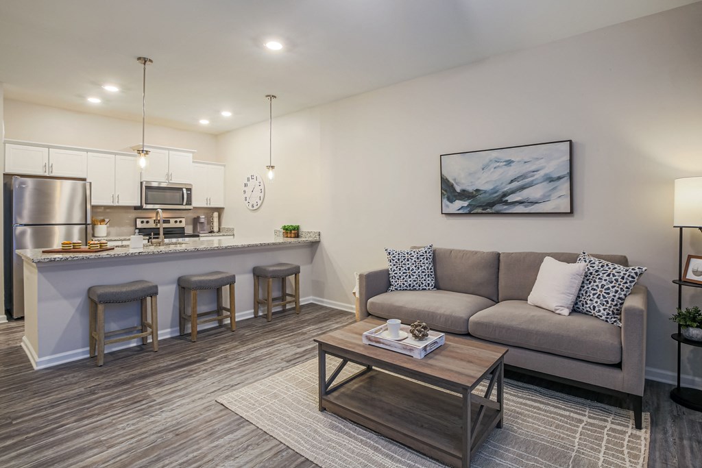 a living room with a couch and a kitchen with a bar