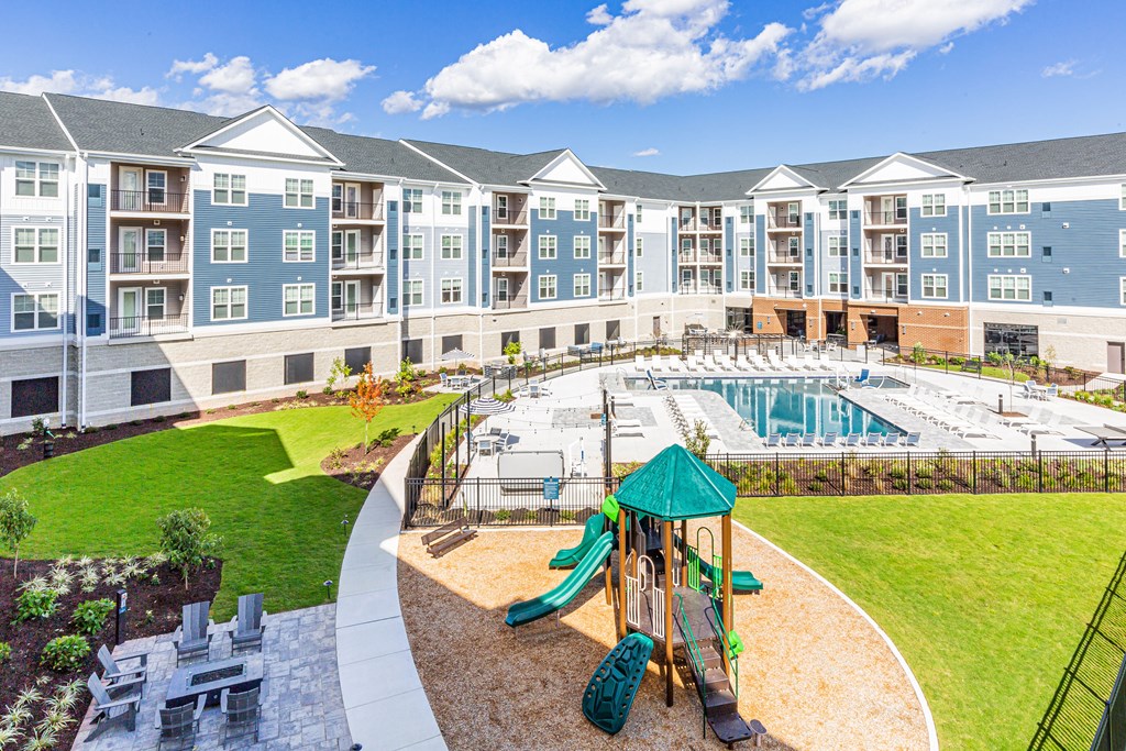 an outdoor playground with a pool and apartments in the background