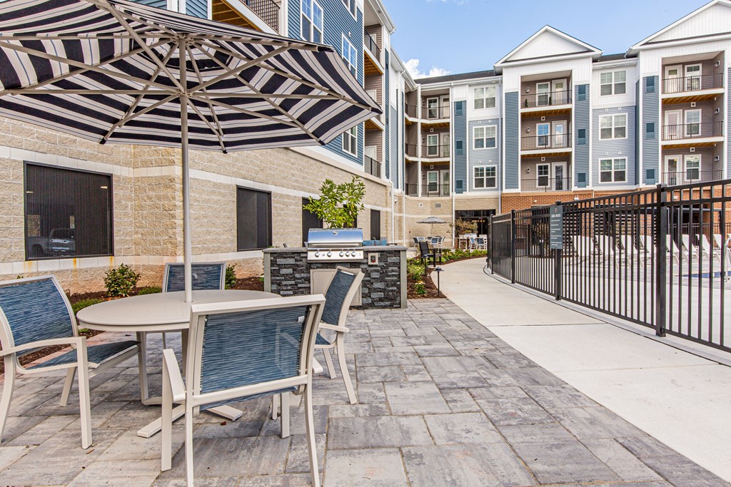 our apartments offer a patio with a table and chairs and an umbrella