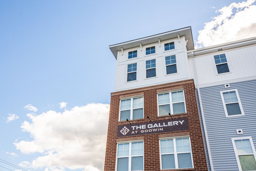 the facade of the galley at acadinity building with a blue cloudy sky