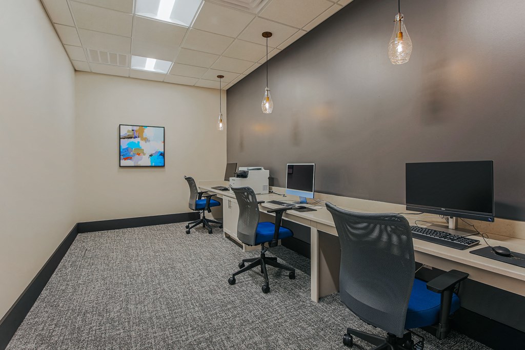 a large room with two desks with computers and a monitor