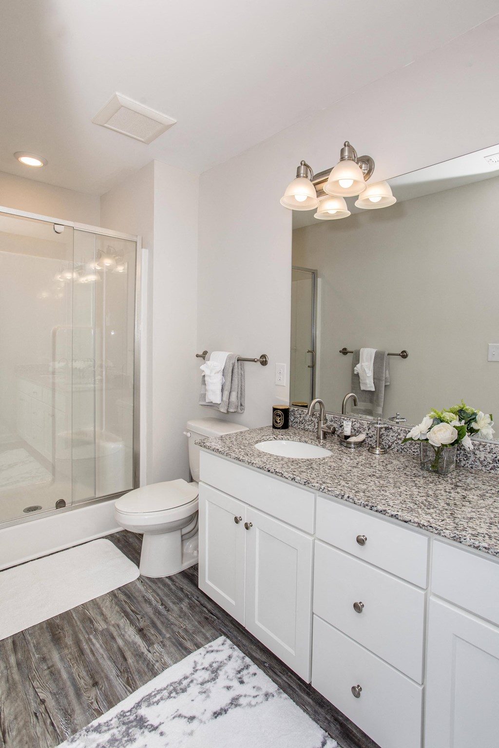 a bathroom with white cabinets and a white toilet and a shower