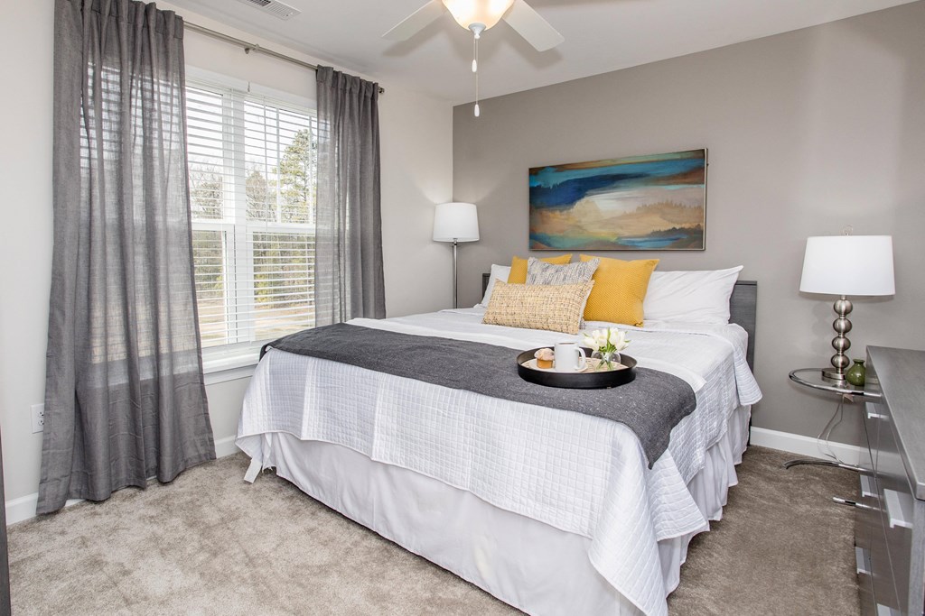 a bedroom with a large white bed and a window