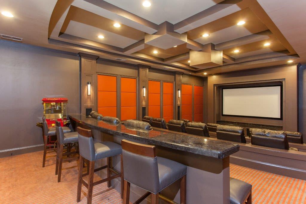 a theater room with a bar and a projector screen