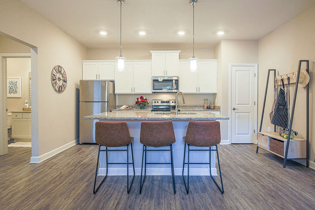 a kitchen with a island and three chairs