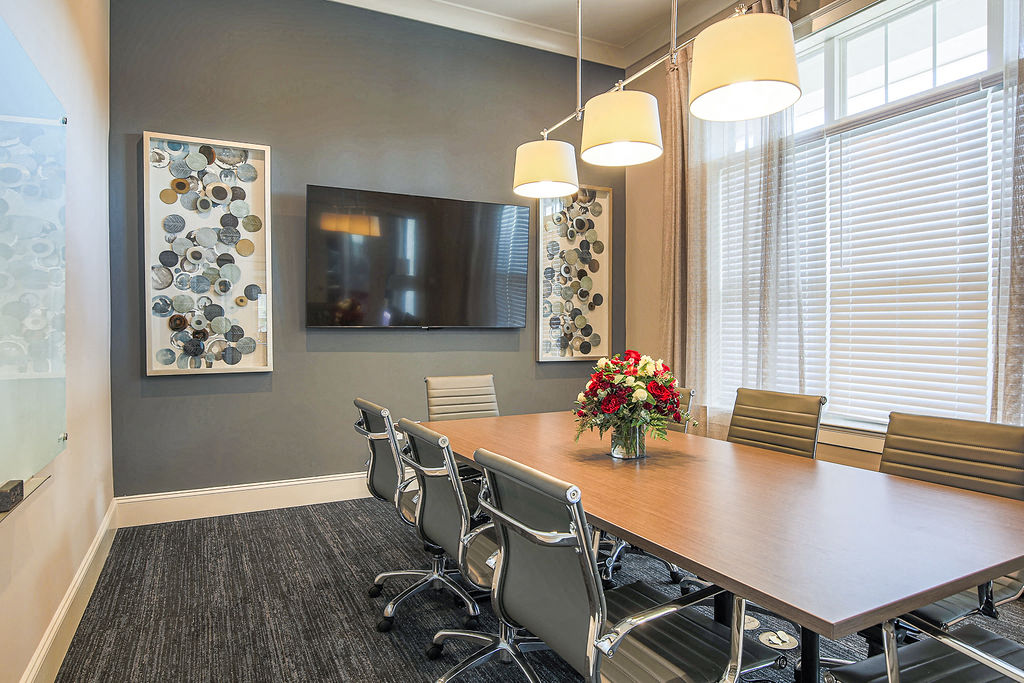 a conference room with a table and chairs and a television