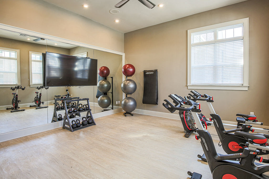 the residence apartments fitness center with exercise equipment and a tv