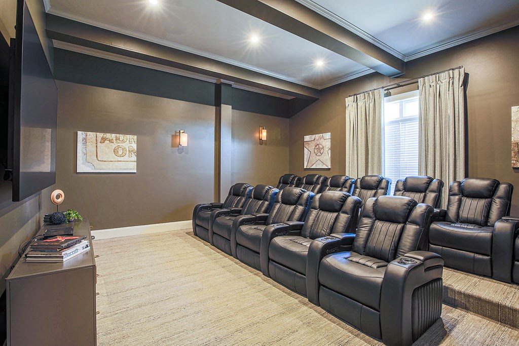 a large screening room with leather chairs and a projector screen