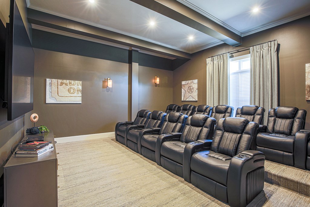 a large screening room with leather chairs and a projector screen