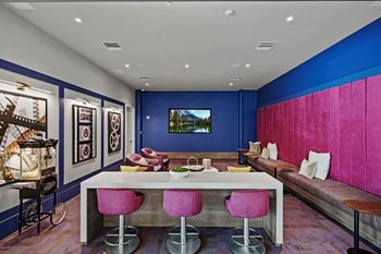 a living room with blue walls and a white table and chairs at Altis Grand Kendall, Miami, FL