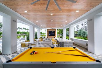 a pool table in a patio area with a fireplace at Altis Grand Kendall, Miami, FL 33186