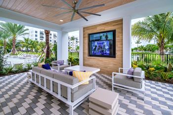 a patio with couches and a table and a television at Altis Grand Kendall, Miami, 33186