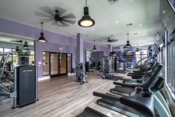 a gym with cardio machines and a ceiling fan at Altis Grand Kendall, Miami, 33186