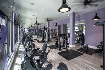 a gym with various machines and chairs in it at Altis Grand Kendall, Miami