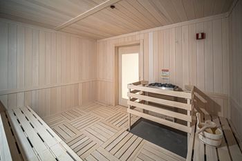 a wooden sauna with a bench and a door at Altis Grand Kendall, Florida